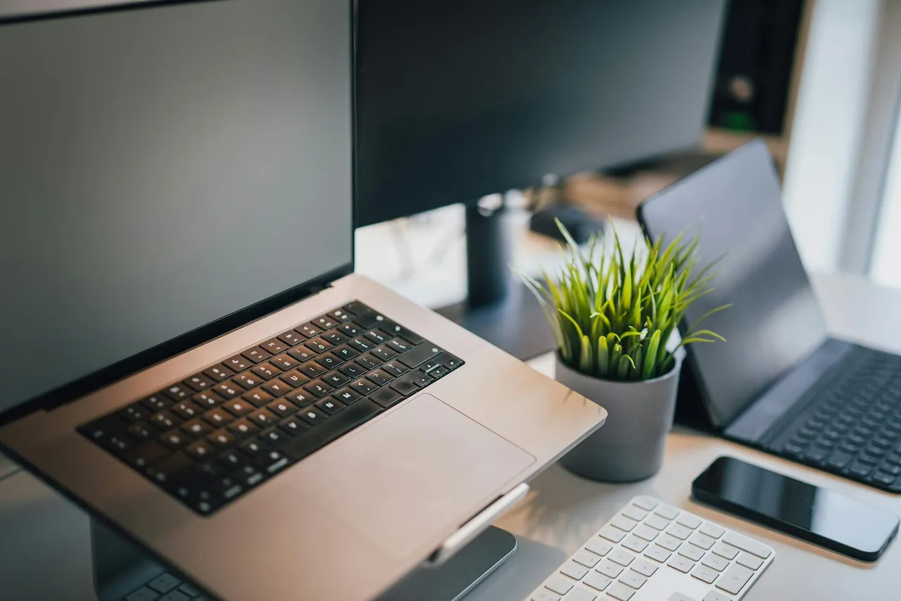 Schlanker Arbeitsplatz mit Laptop in einer ruhigen modernen Büroumgebung.