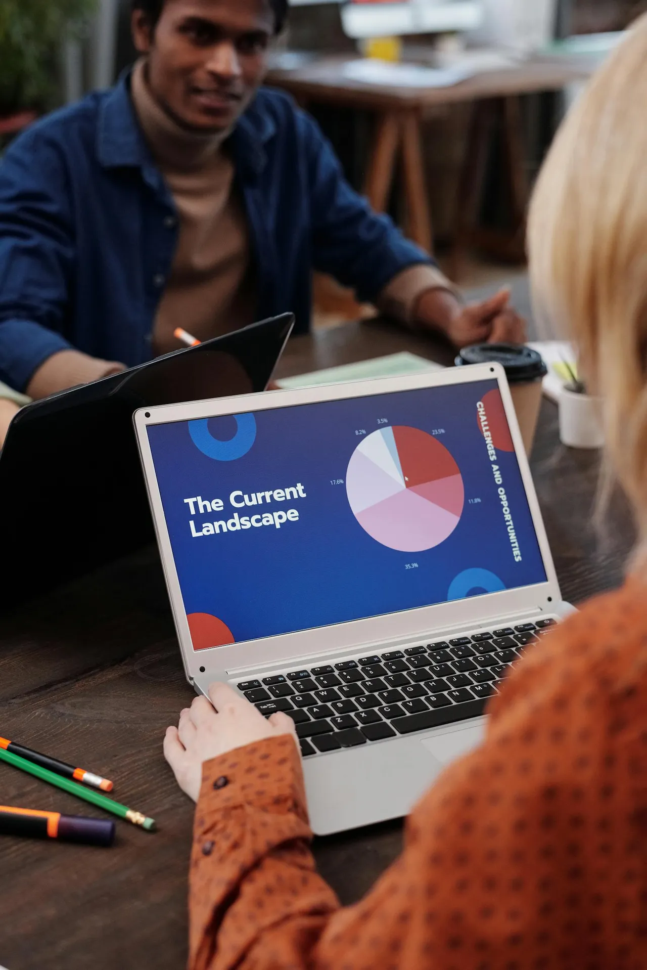 Team mit Laptops in einer modernen Arbeitsumgebung während einer digitalen Präsentation.
