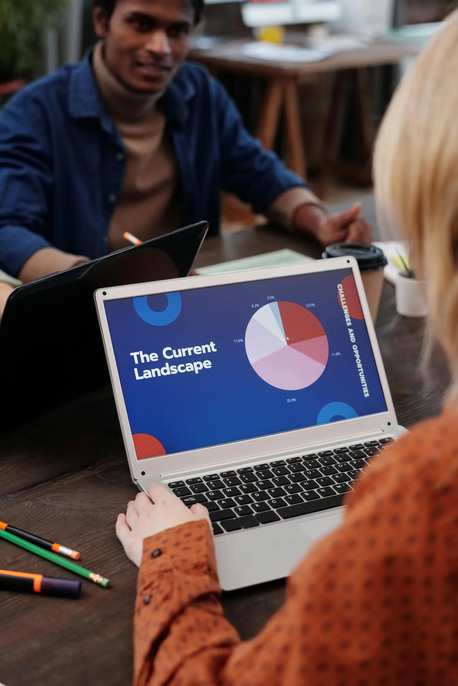 Team mit Laptops in einer modernen Arbeitsumgebung während einer digitalen Präsentation.