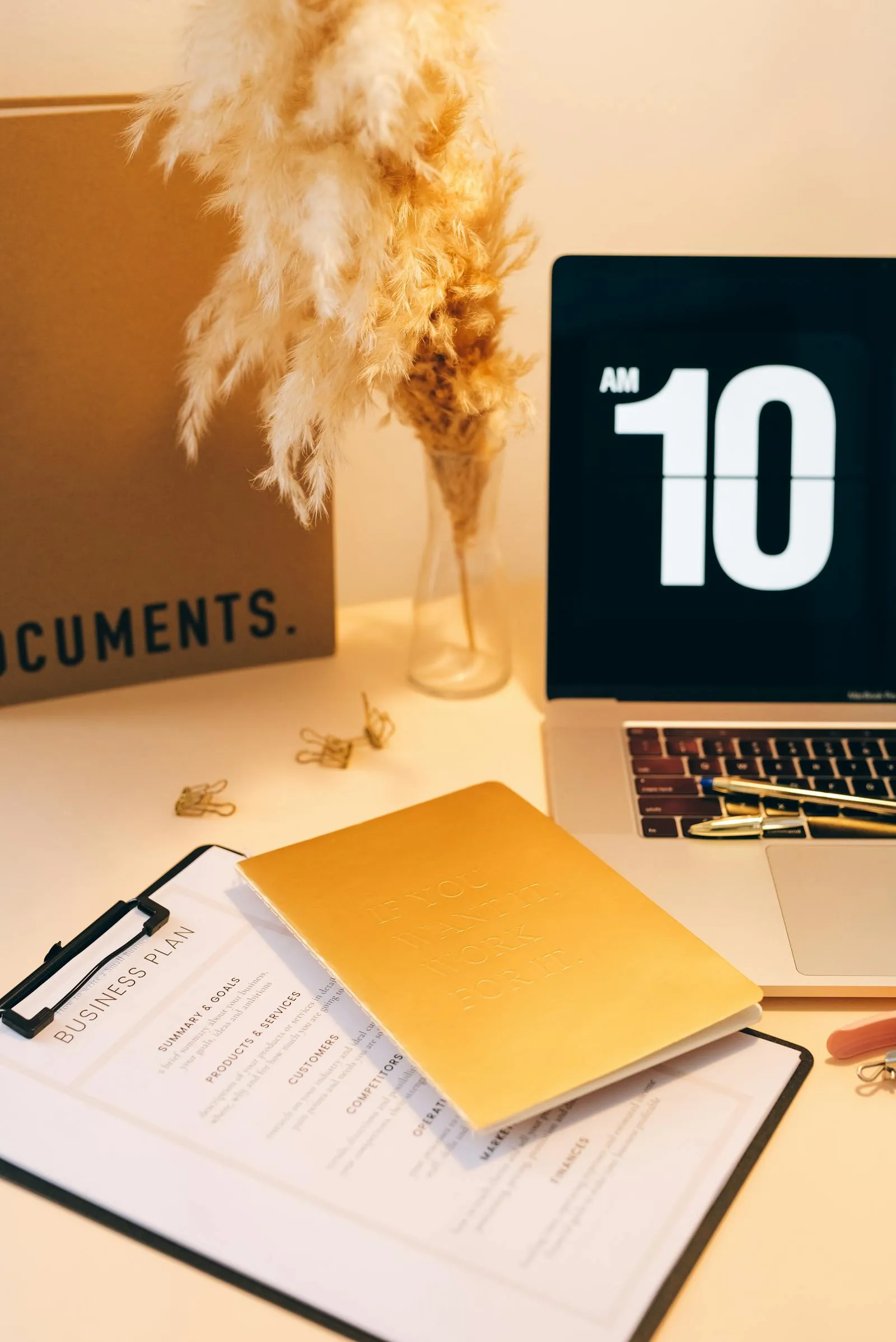 Aufgeräumter Schreibtisch mit Dokumenten, Laptop und Arbeitsmaterialien für strukturierte Prozessarbeit.